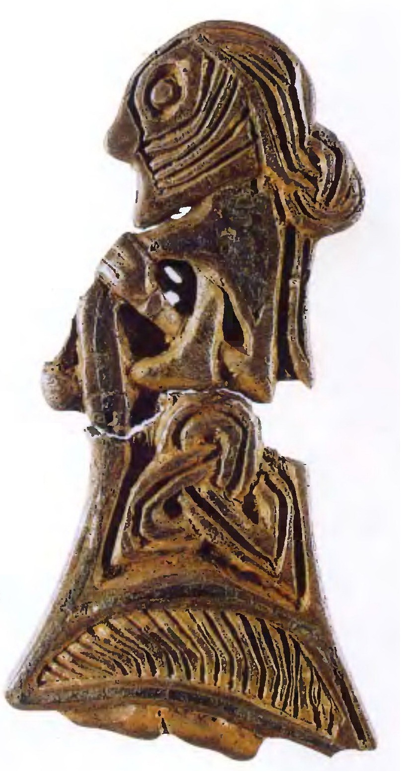 Перед нами датский амулет X столетия с изображением женщины-скандинавки, он имеет 4 см в высоту и выполнен из серебра, покрытого позолотой и эмалью. На женщине украшенное платье, надетое, по-видимому, поверх плиссированной рубахи, левая рука держит шаль, покрывающую плечи фигуры. Длинные волосы расчесаны и завязаны узлом сзади (Государственный музей Дании, Копенгаген).
